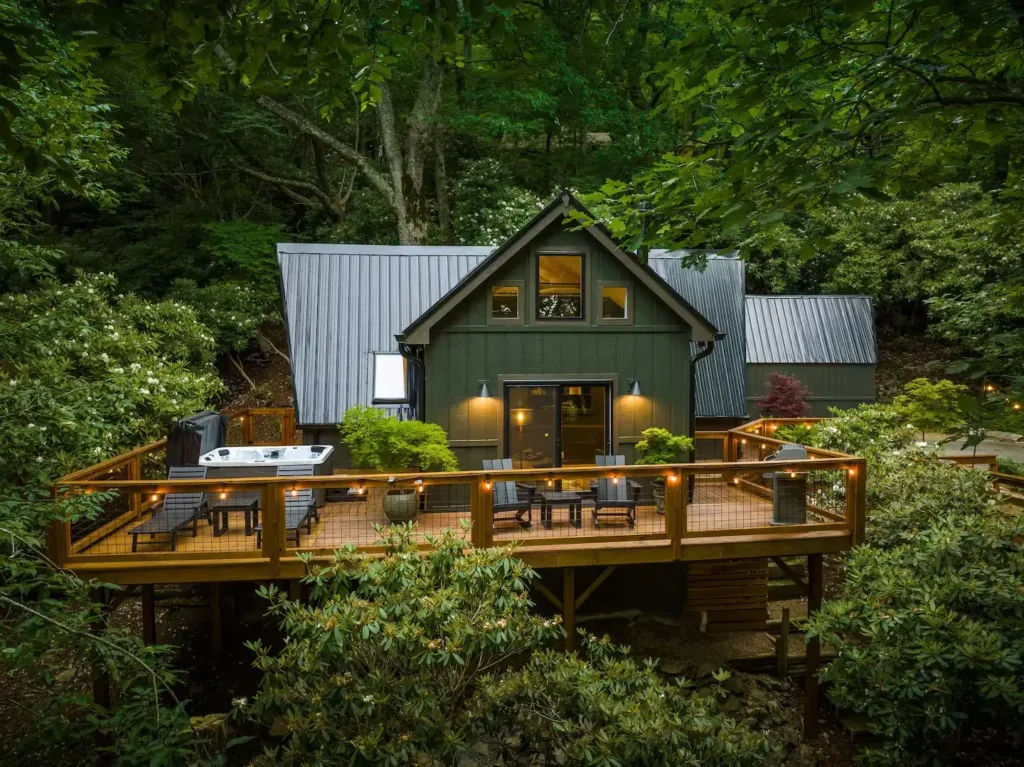 Moon-A-Chalet A-frame cabin rental exterior with large wooden deck and fire pit, surrounded by lush forest in Blowing Rock, NC