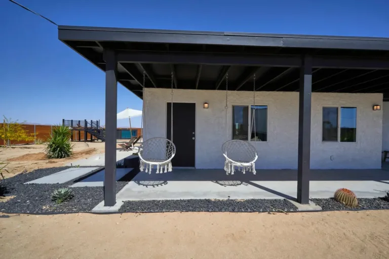 Modern Joshua Tree Airbnb cabin patio (Casa Joshua Tree style) with hanging chairs and desert landscaping