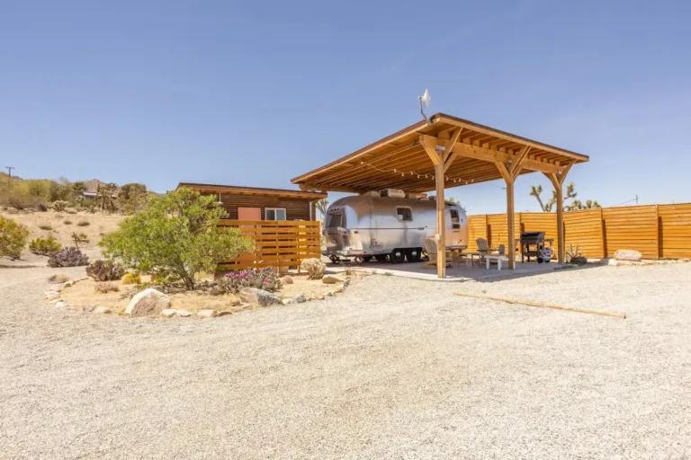 Vintage Airstream trailer Airbnb setup in Joshua Tree with covered patio and desert landscape