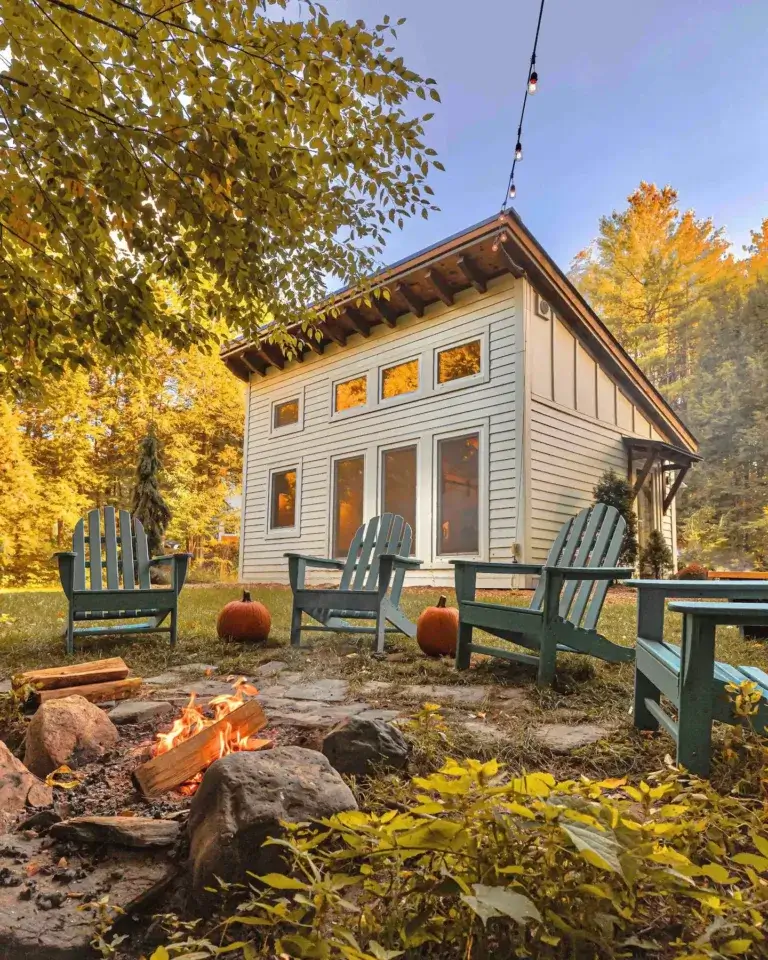 Honeycrisp Cottage tiny timber frame cabin rental with cozy fire pit and Adirondack chairs in Putney, Vermont autumn setting