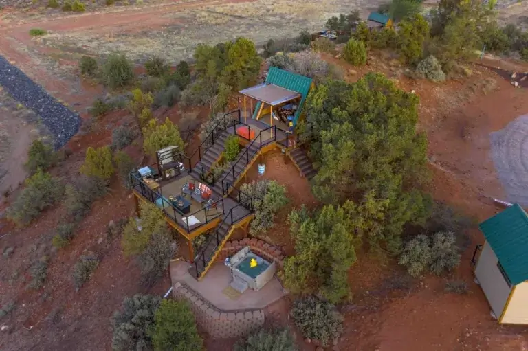 Aerial view of Zion Eco Cabin rental showing A-frame, multi-level decks, and private hot tub on Utah hillside near Zion