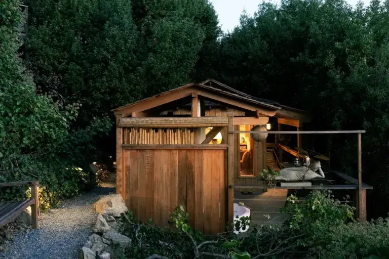Asian-inspired Bird's Nest Bungalow rental exterior nestled into lush green hillside in Stinson Beach, California