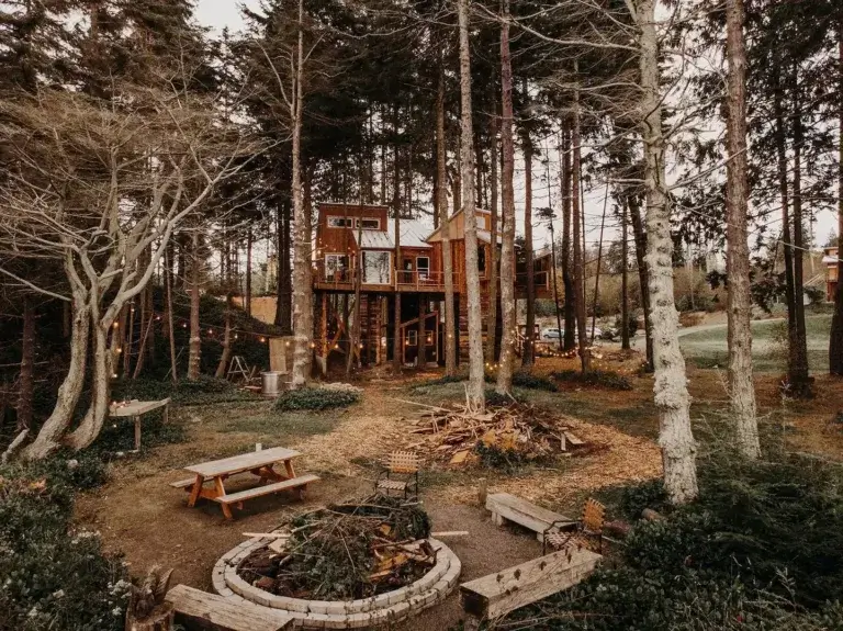 Elevated Eagles Nest treehouse rental with large fire pit area below in Port Angeles, Washington woods