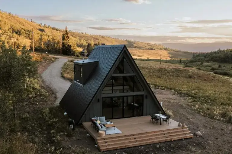 Modern backcountry A-frame cabin rental with deck set on open mountainside near Kremmling, Colorado