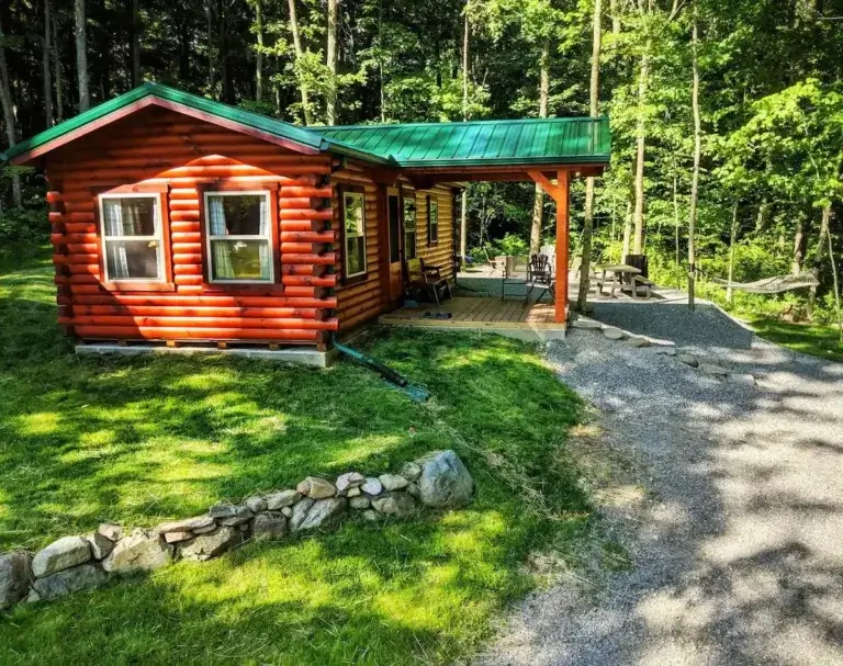 Classic log cabin rental The Cabin at Maple View with green roof and porch in secluded Ohio woods, Urbana