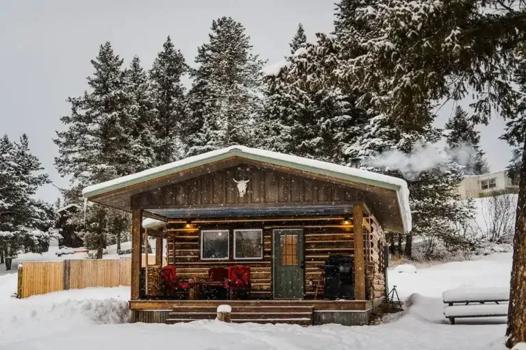 Cozy Enchanting log cabin rental (Blackfoot Cabin) with smoking chimney in snowy Montana winter near Glacier NP
