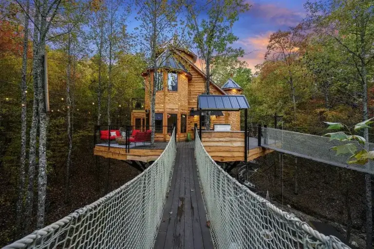 Modern Mountain Fork Landing cabin rental exterior with fire pit in gravel clearing at dusk, Broken Bow, Oklahoma