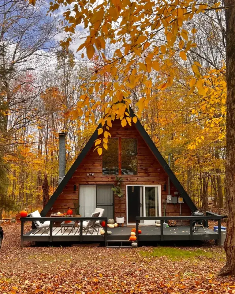 Charming wood A-frame cabin rental with deck surrounded by vibrant autumn foliage in the Pocono Mountains, Hamlin, PA