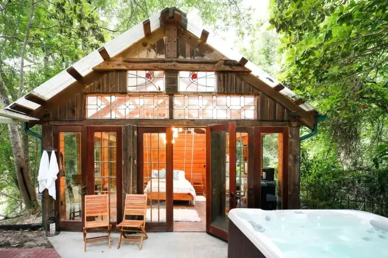 Romantic Naturalist Boudoir cedar cabin rental with open glass front and outdoor hot tub in Texas Big Thicket