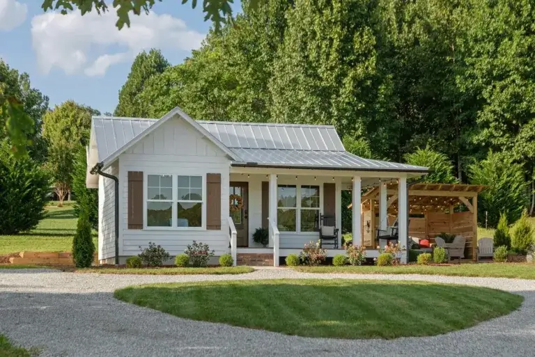 Charming white Cottage at Eagles View rental with front porch and pergola patio in Hendersonville, North Carolina
