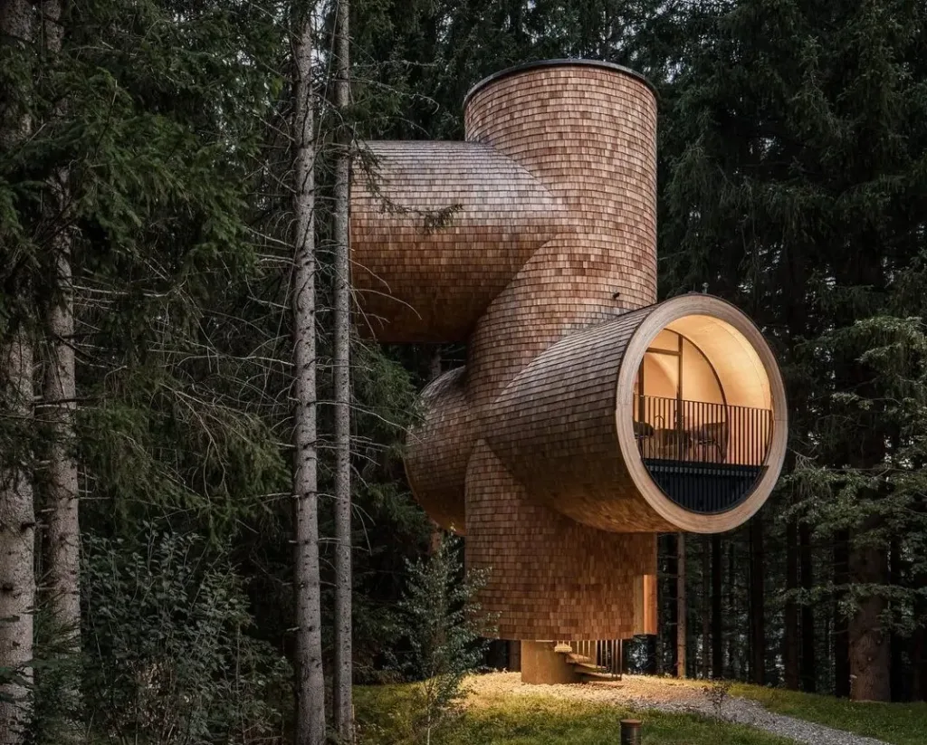 Unique Treehouse Bert in Austria with whimsical shingle-clad tubes embodying Scandinavian-inspired woodland design and connection to nature.