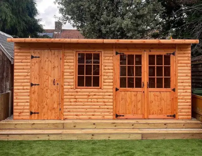 A custom-designed shed log cabin featuring a unique angled front, a side extension, and a modern pent roof.