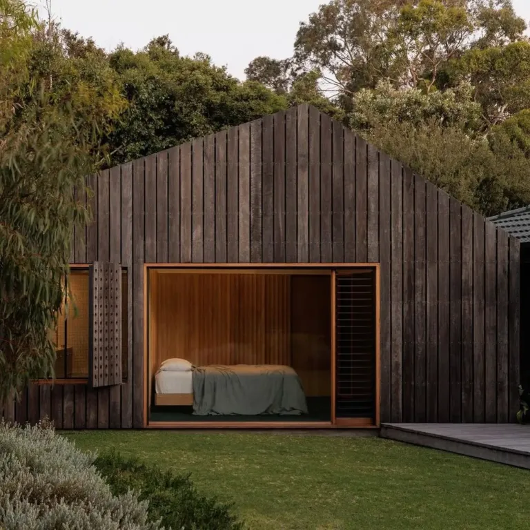 Modern house extension with a clean, minimalist roofline and large windows, integrating with the existing structure.