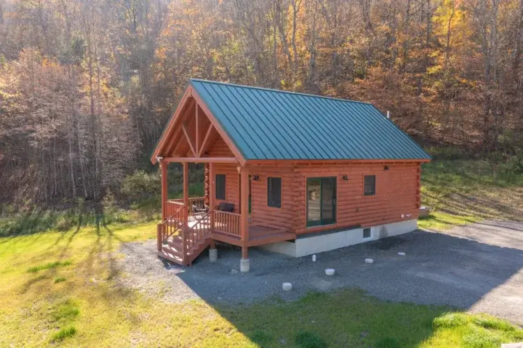 An aerial view of the Northwood log cabin kit in a beautiful autumn forest setting.