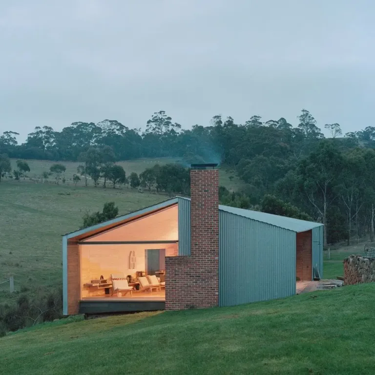 Sustainable and rustic modern building exterior made of wood and metal, situated on a historic farm.
