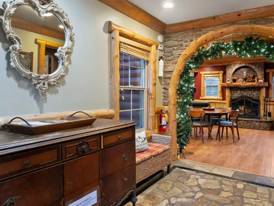 The rustic stone entryway of a Big Bear log cabin, offering a glimpse of the main living room and fireplace.