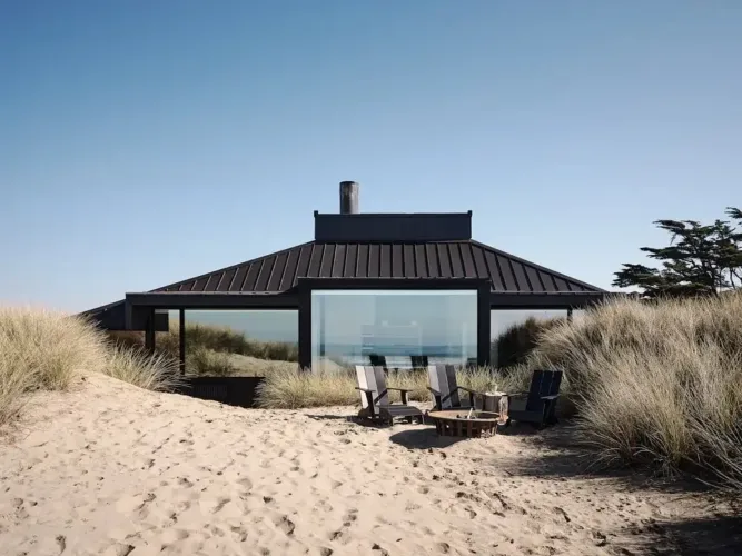 Revitalized 1960s beach house exterior with dark cedar siding and light wood accents, blending with sand dunes.