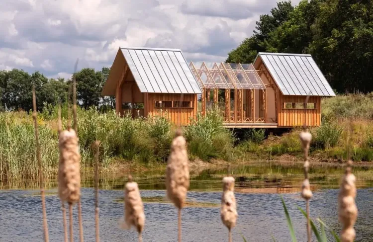 Innovative adaptive cabin with untreated larch wood exterior, designed to open and close to connect with nature.