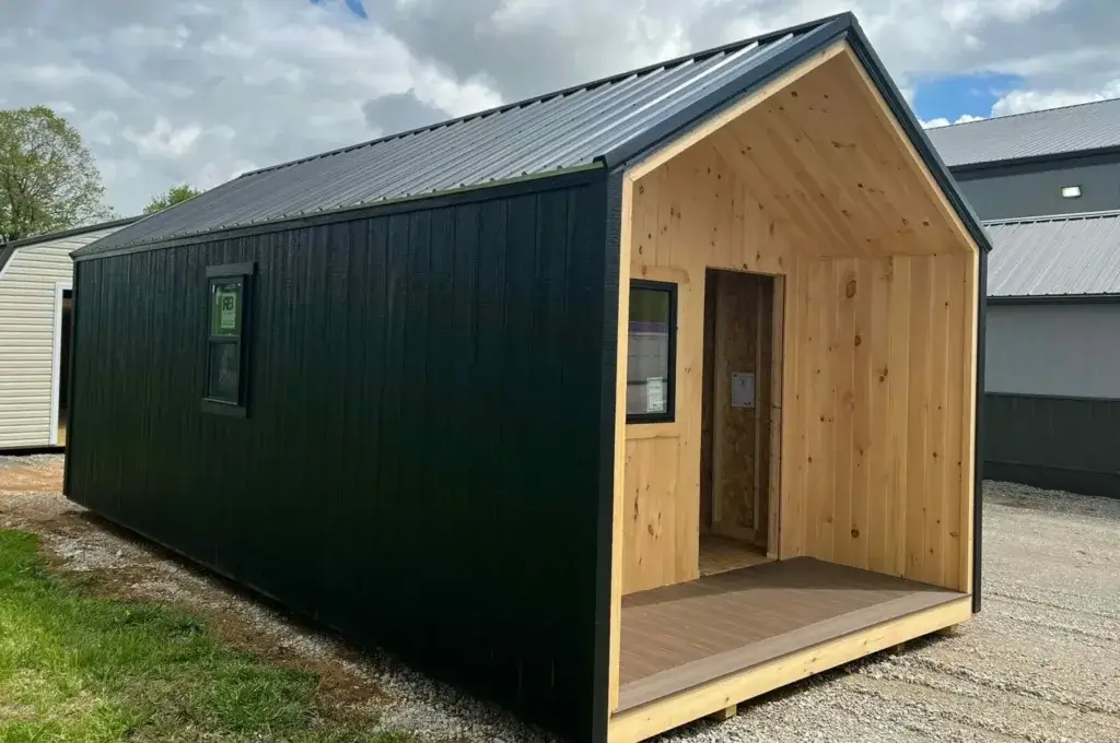 A 14x40 Nordic tiny home shell with black vertical siding, a metal roof, and an unfinished natural wood porch area.