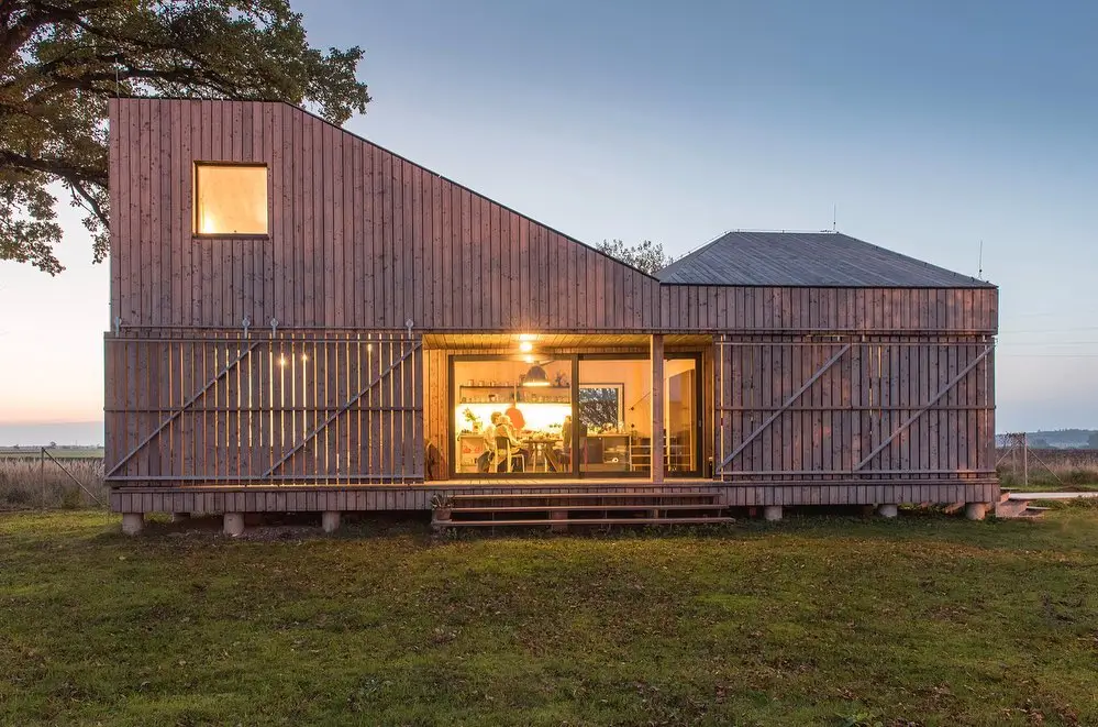 Sustainable wooden house exterior in the Czech Republic with a "burn and stain" finish, featuring large windows and a modern form.