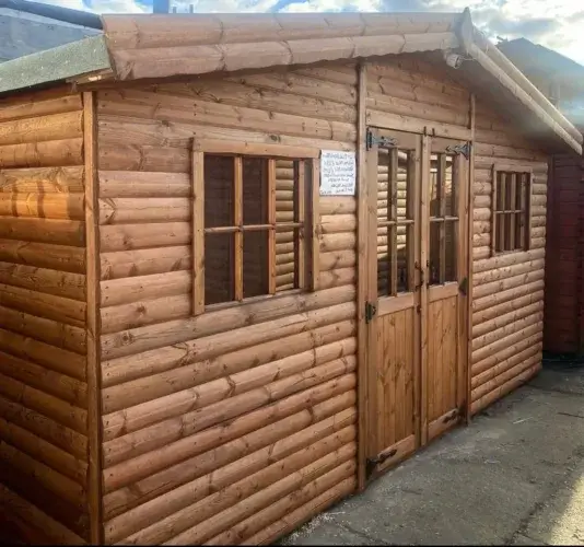A beautiful shed log cabin with a warm cedar stain, modern pent roof, and double stable-style doors.