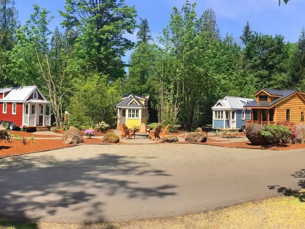 A tiny house community in Ohio with several colorful homes arranged around a common area with a fire pit.