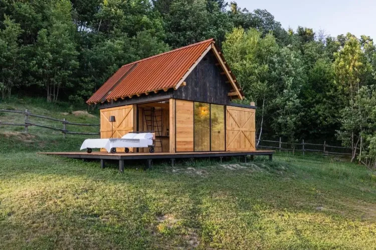 Simple, rectangular cabin exterior made of beautiful chestnut wood, inspired by traditional Alpine huts.