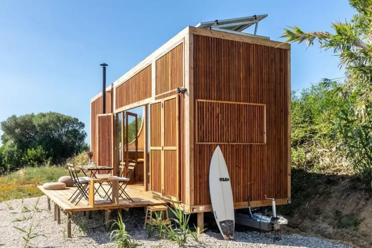 Compact tiny home exterior with a robust steel frame and natural wood cladding, designed for efficient living.