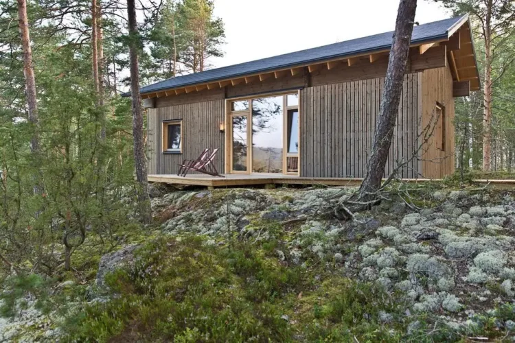 Finnish summer cabin exterior with high ceilings and huge windows that blur the lines between indoor and outdoor living.