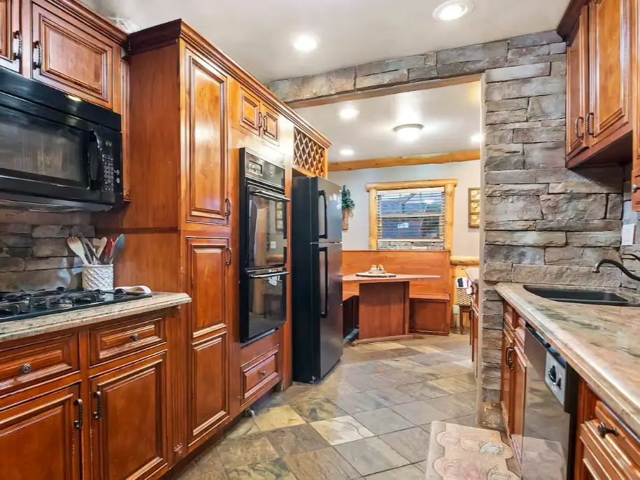 The chef-grade double oven and custom cabinetry in a luxury Big Bear log cabin kitchen.