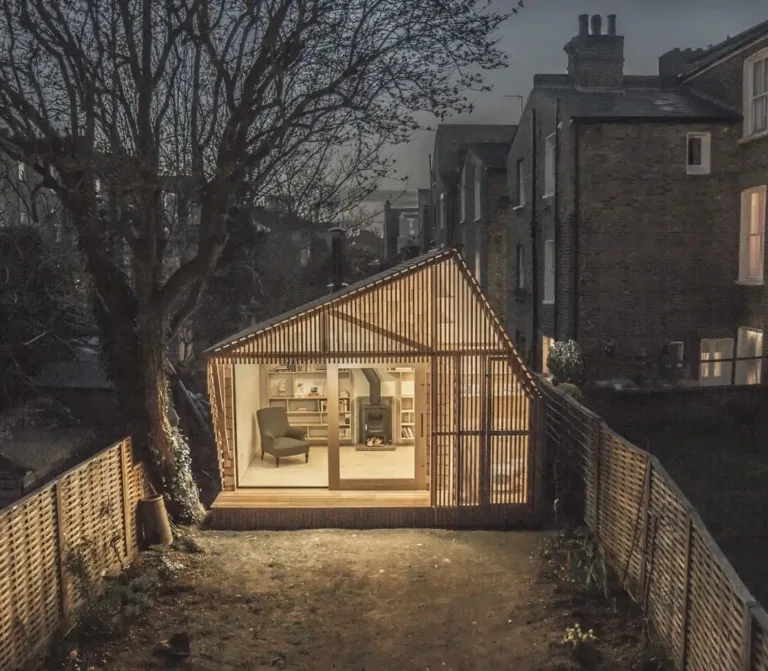 Unique wooden garden shed exterior with slatted facade and a large window, embodying a whimsical Scandinavian style.