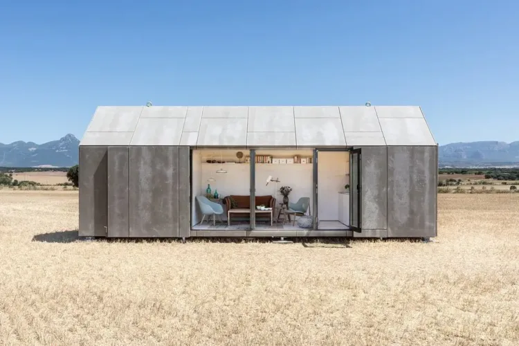 Charming portable cabin exterior with sleek gray panels and large windows, designed for sustainable and compact living.
