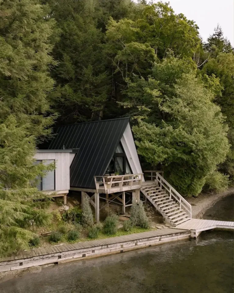 A-frame lakeside cabin exterior in Quebec, featuring a large A-frame window with stunning lake views.