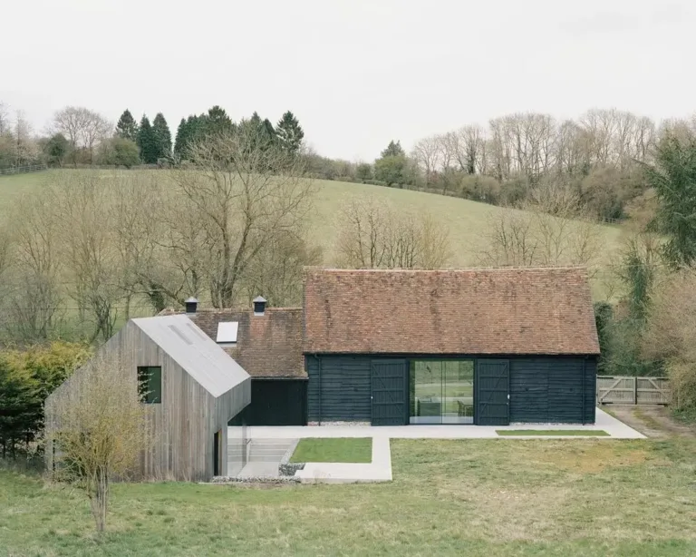 Converted barn exterior blending historic features with modern, sleek black finishes and Scandinavian style.