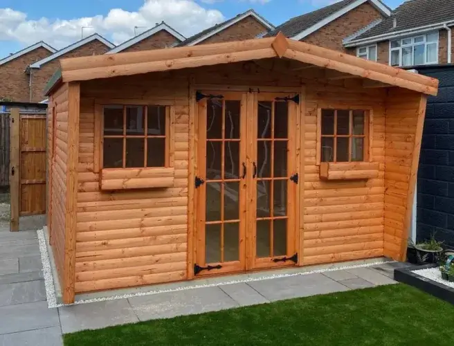 A well-built, mid-size shed log cabin with a dark wood stain, representing a popular kit choice for backyards.