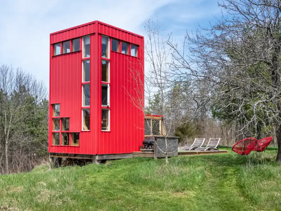 Inspiring shipping container home designs: A vibrant red tiny house with a modern, space-efficient architectural style.