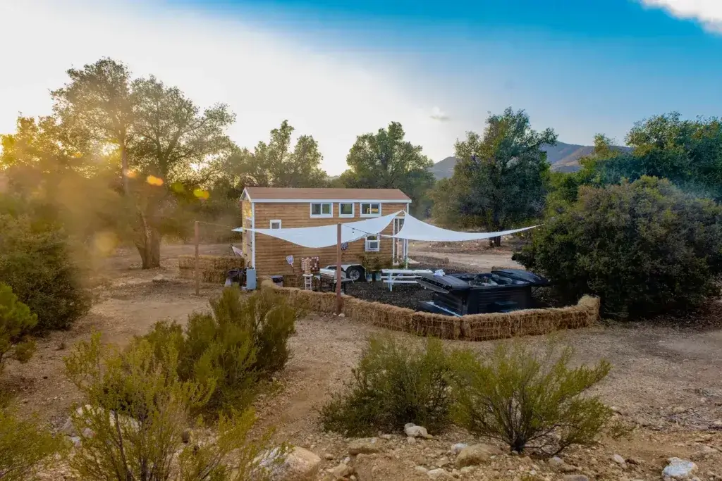 An aerial view of a 200 sq ft tiny house in a beautiful, secluded landscape, showcasing the potential for off-grid living.