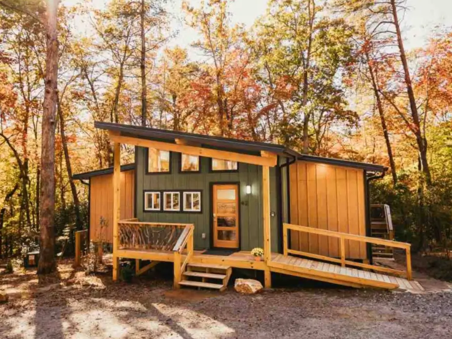 The exterior of the modern 900 sq ft Trahlyta cabin in autumn, showing the accessible ramp and front porch.