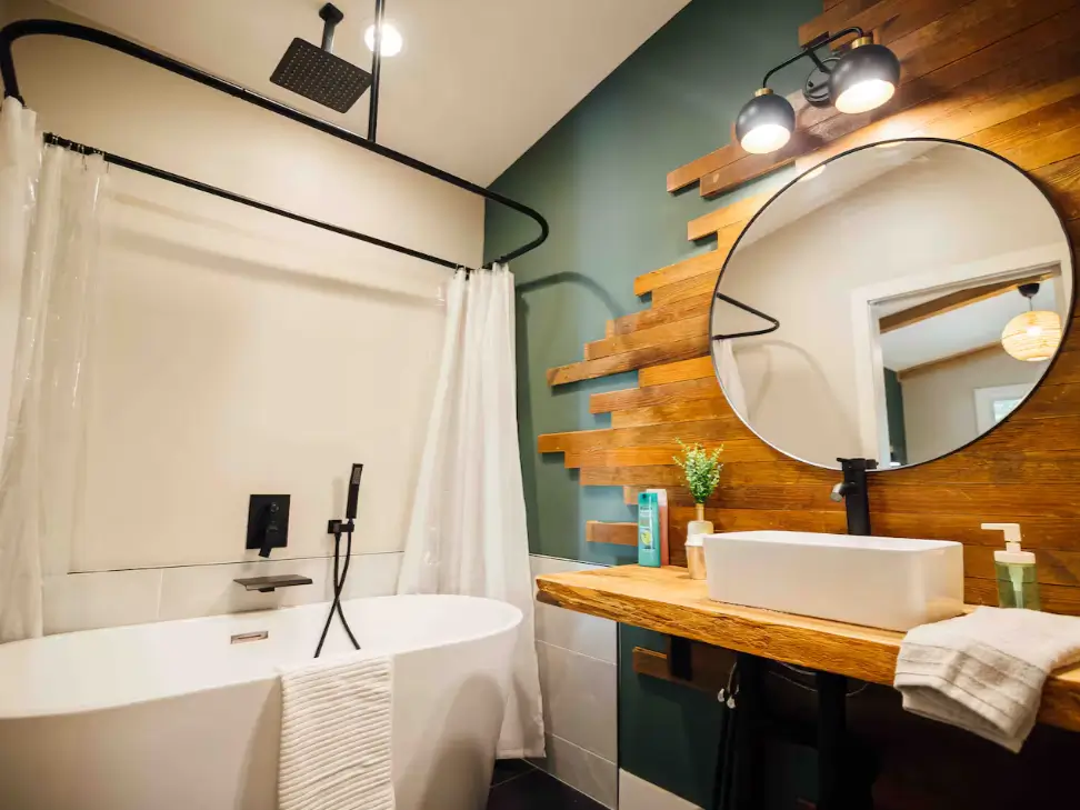 The stylish bathroom in the 900 sq ft cabin, featuring a freestanding tub and a unique wood accent wall.