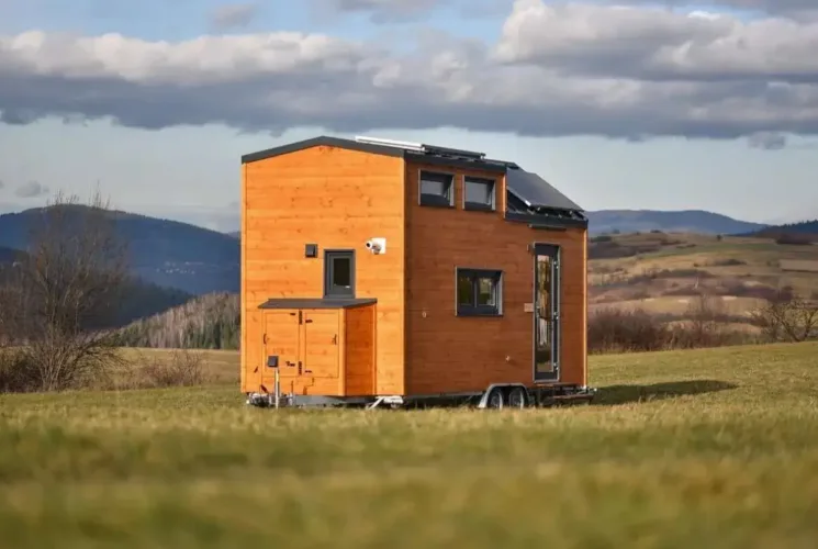 The Sunshine tiny home on wheels with wood siding and a loft, an eco-friendly prefab home under 50k.