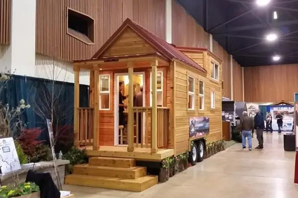 A cottage-style tiny home from Tiny Pacific Houses with a covered porch, a charming prefab home for under 50k.