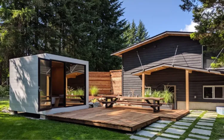 The 106, a modern backyard studio pod with a glass wall and deck, a compact modular home for under 50k.