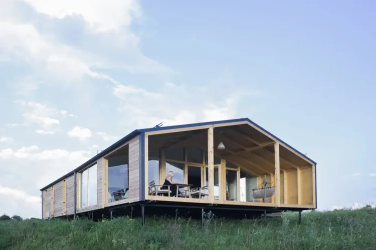 The DD 43 by DublDom, a long modern modular home with a glass wall and wood frame, a prefab home for under 50k.