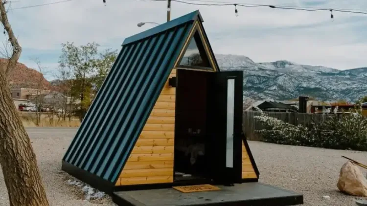 The ALT 12-foot A-Frame Tiny Cabin with a dark metal roof, a compact prefab cabin for under 50k.