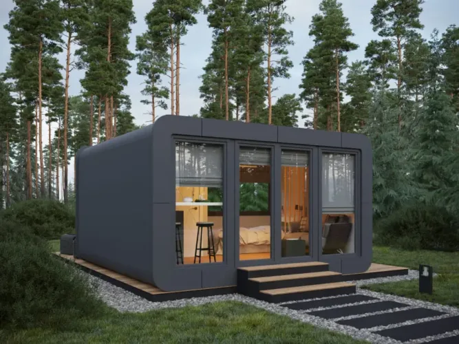 The O2M Camping pod, a dark grey modern prefab cabin with rounded edges, a glamping modular home under 50k.
