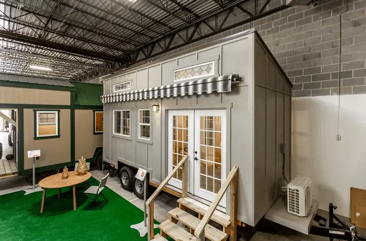 The Grand Jct tiny home, showing a cottage style with french doors, a charming modular home for under 50k.