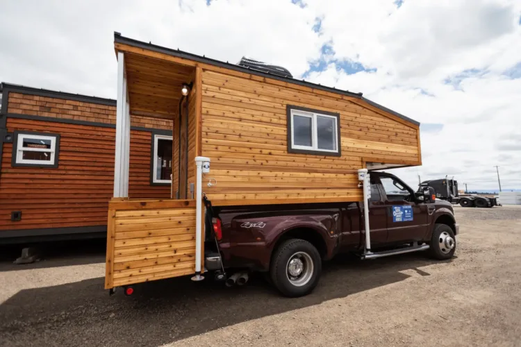 The Tiny Traveler truck camper by Tiny Smart House, with wood siding, a highly mobile prefab home for under 50k.
