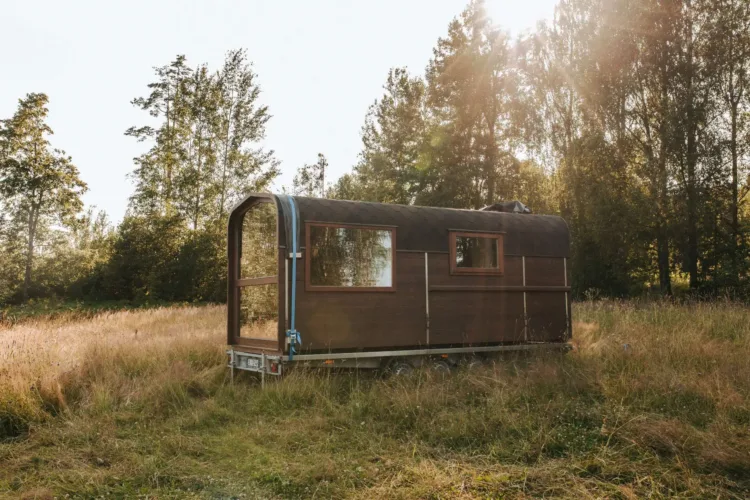 The Nature Pod tiny home on wheels with a curved roof and full glass front, an affordable prefab home under 50k.