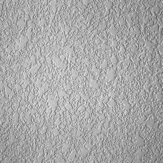 Detailed knockdown wall texture in a light gray finish, showcasing its characteristic flattened peaks and valleys.