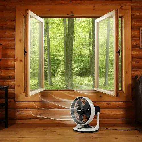 A clean and airy log cabin interior with open windows and a fan circulating fresh air, illustrating the benefits of proper wall cleaning.